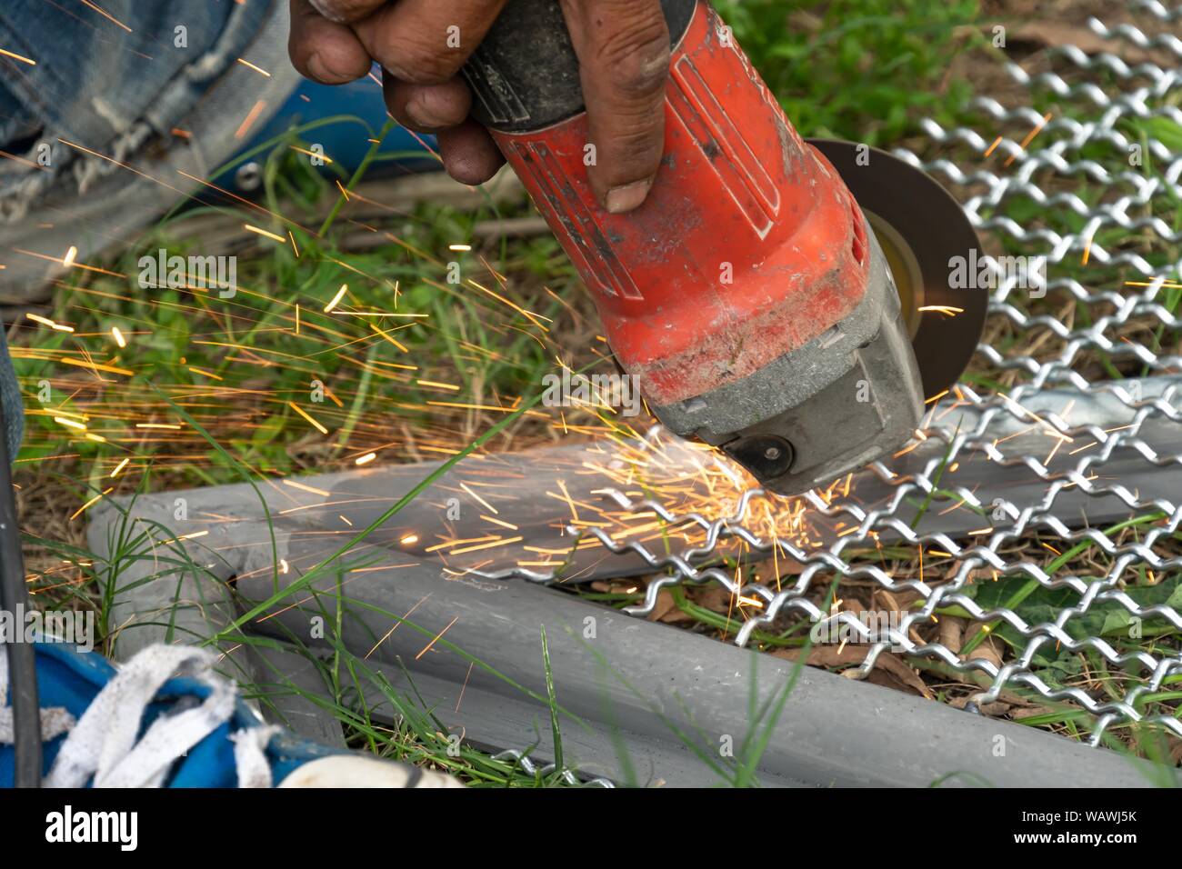 man used angle grinder without cover guard cutting metal net to make