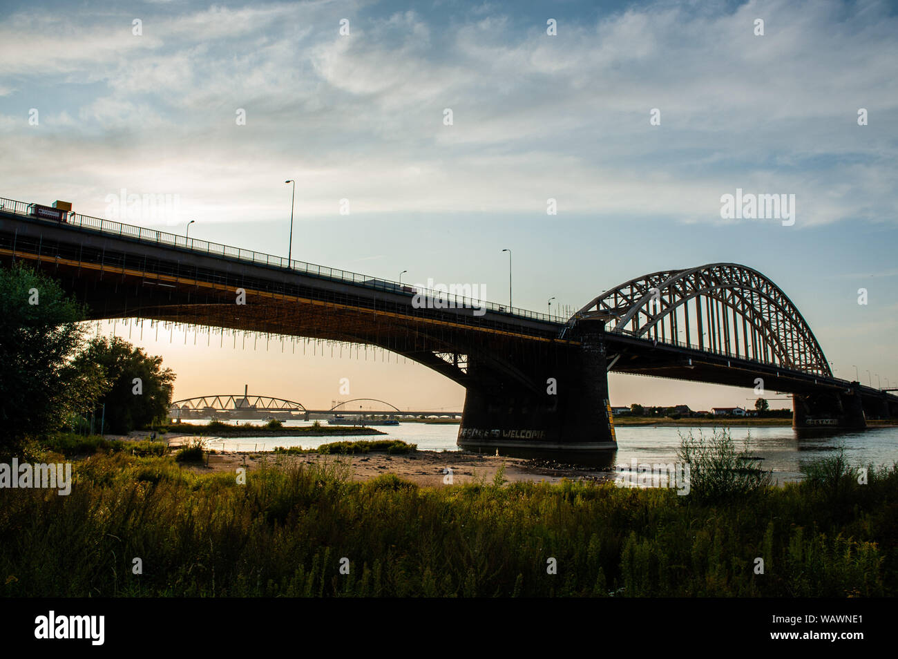 Nijmegen, Gelderland, Netherlands. 21st Aug, 2019. View of the Waalbrug bridge during sunset.The Ooijpolder is a beautiful area for walking and recreation close to the Waalbrug Bridge and surrounded by the Waal River. The area is located east of the city of Nijmegen in the province of Gelderland. Credit: Ana Fernandez/SOPA Images/ZUMA Wire/Alamy Live News Stock Photo