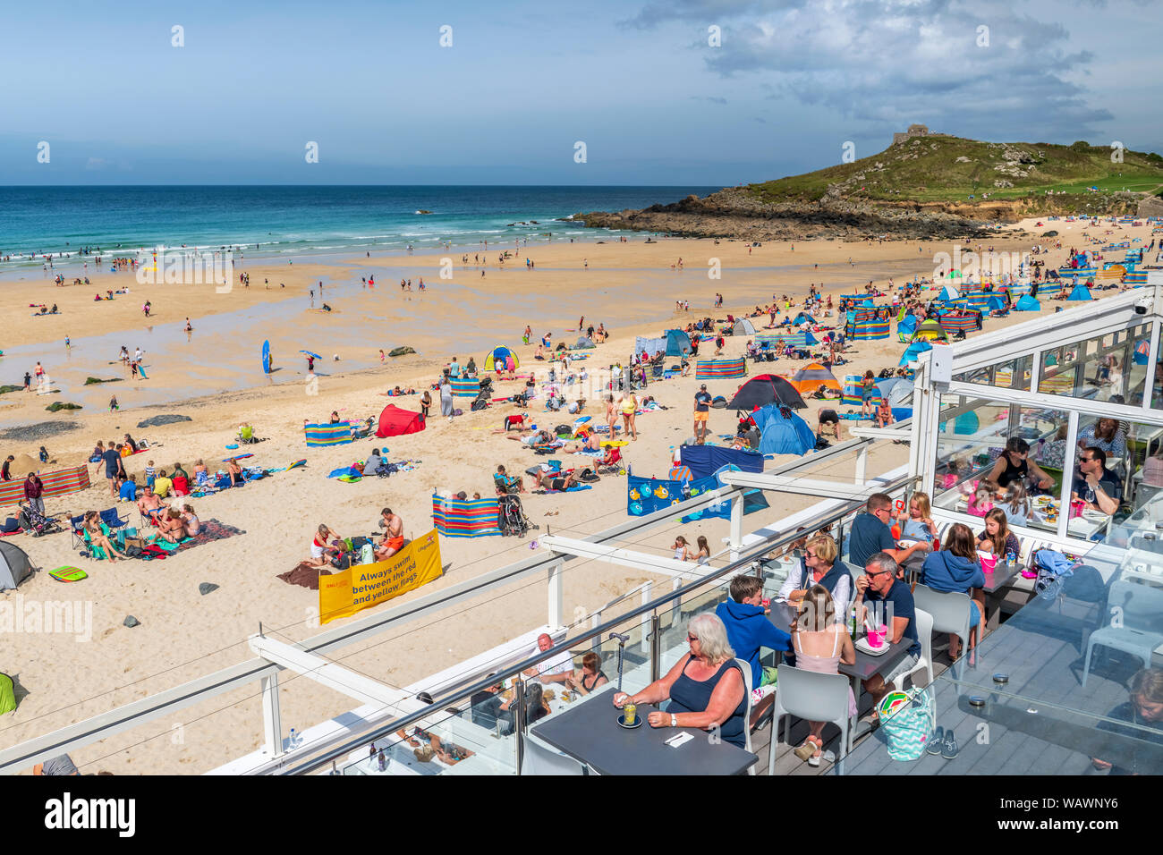 St Ives in West Cornwall, England. Wednesday 21st August 2019. UK Weather: Holidaymakers enjoy a day of warm sunshine and a gentle breeze at Porthmeor Stock Photo
