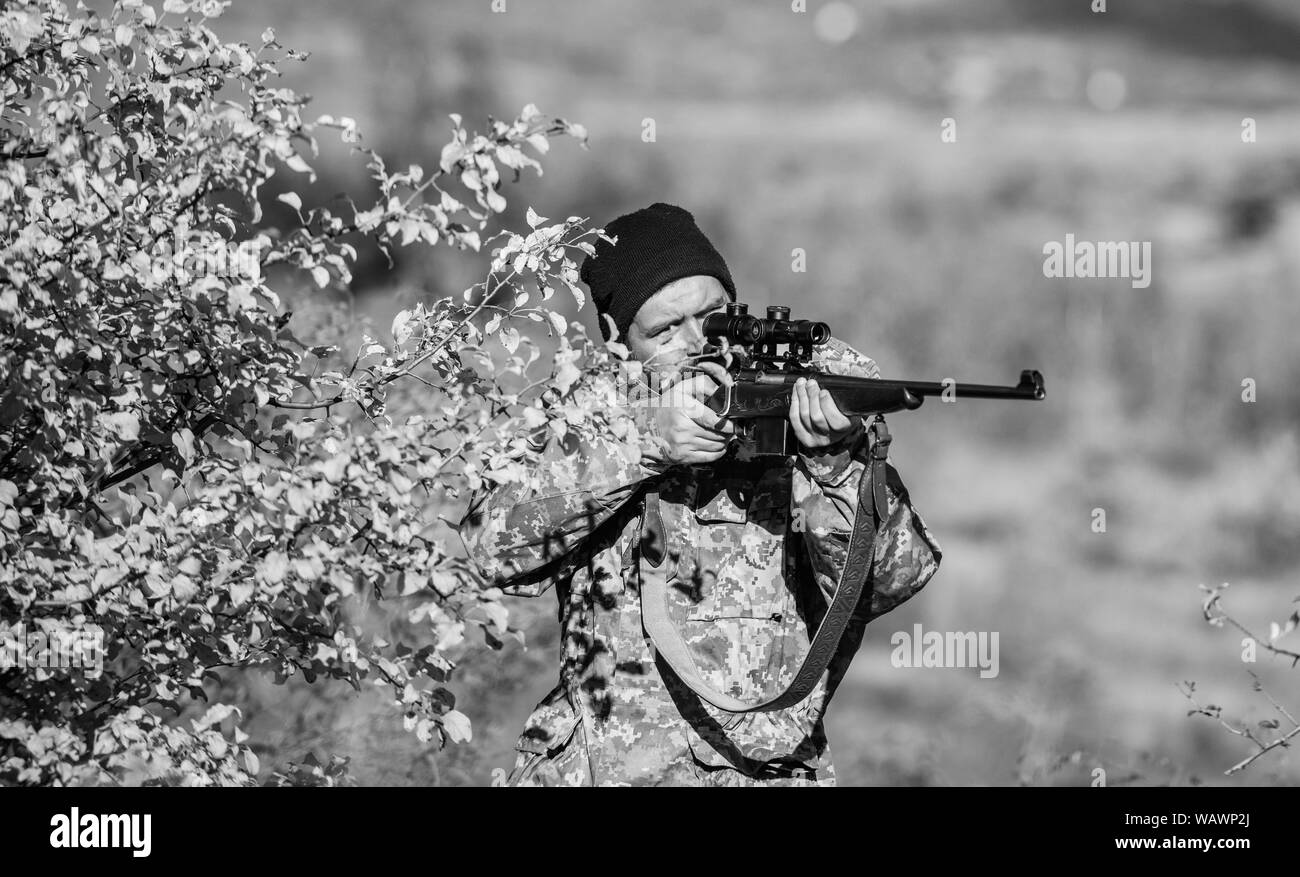 Man hunter with rifle gun. Boot camp. Bearded man hunter. Army forces. Camouflage. Military uniform. Hunting skills and weapon equipment. How turn hunting into hobby. Military Operation in Action. Stock Photo