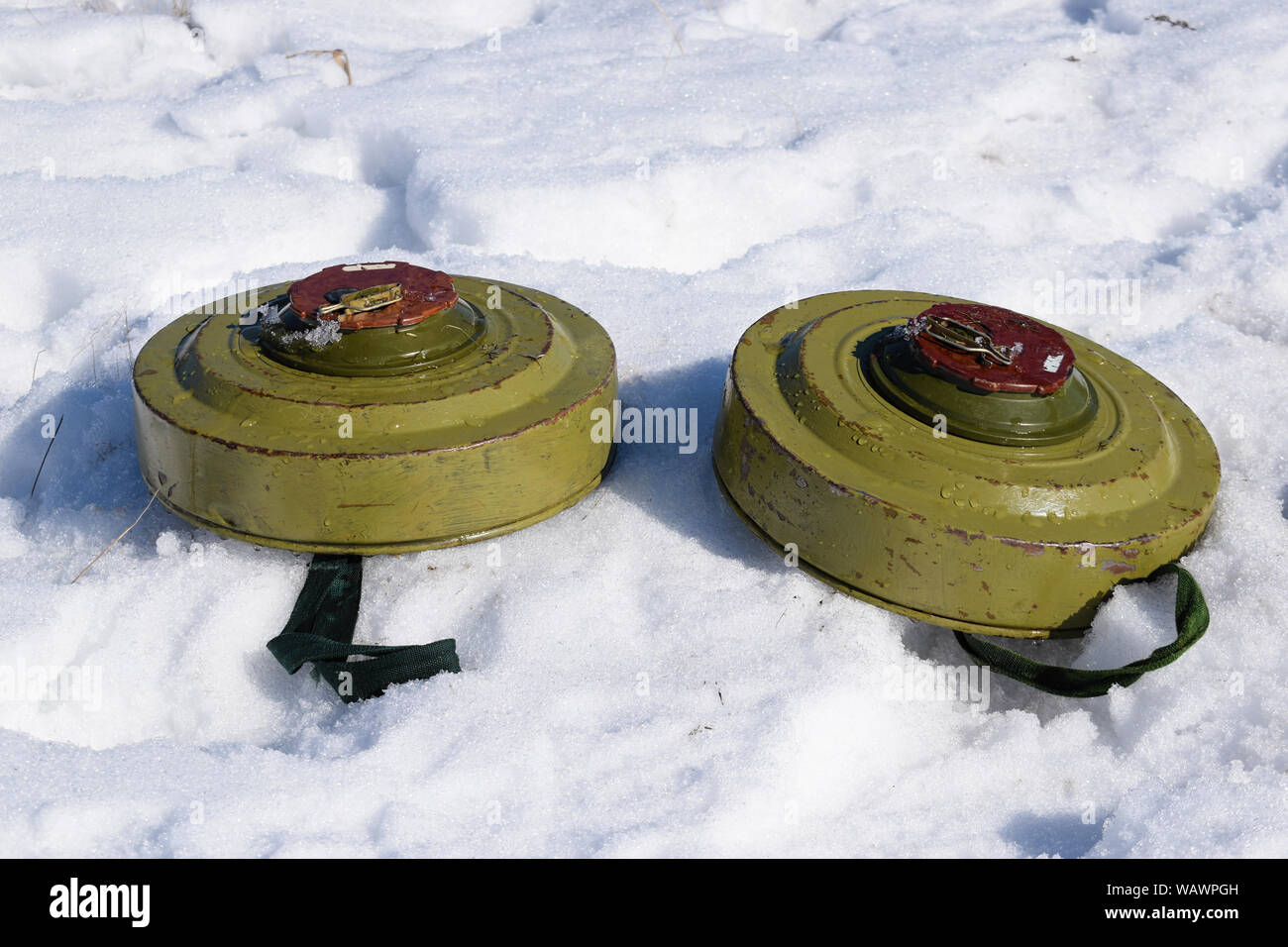 Anti-tank land mines on the snow fully armed and ready to be installed on the battlefield Stock Photo