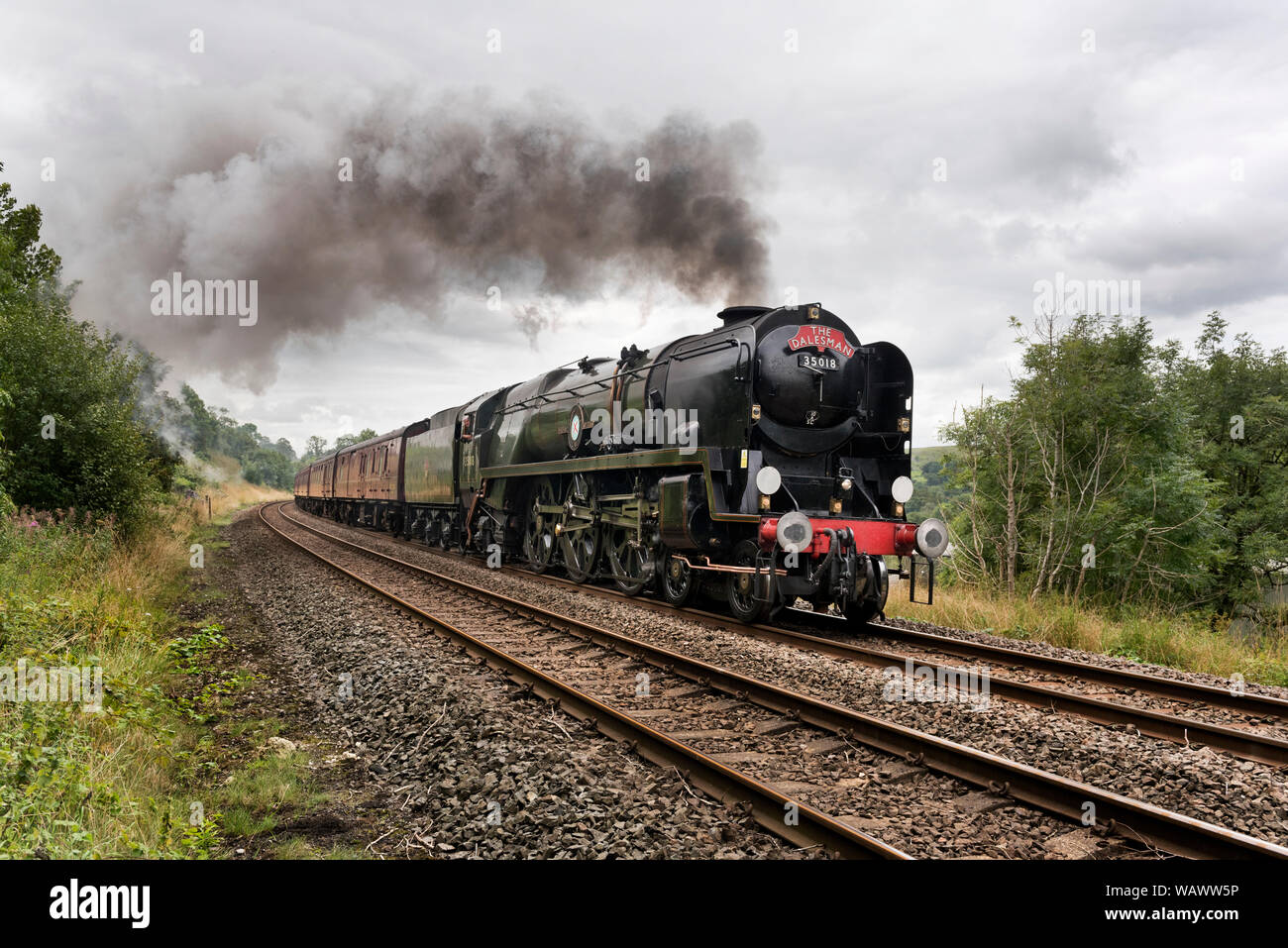 Steam locomotive 'British India Line' hauls 'The Dalesman' train up the steep gradient of the Settle Carlisle railway line towards Carlisle. Stock Photo