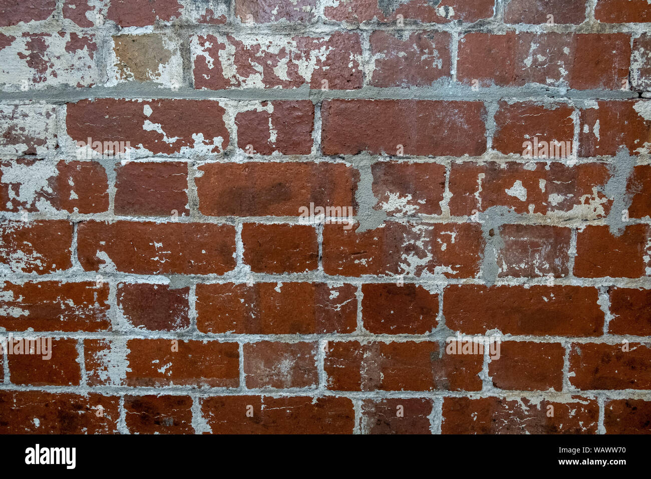 Vintage brick wall with peeling white paint background texture Stock Photo