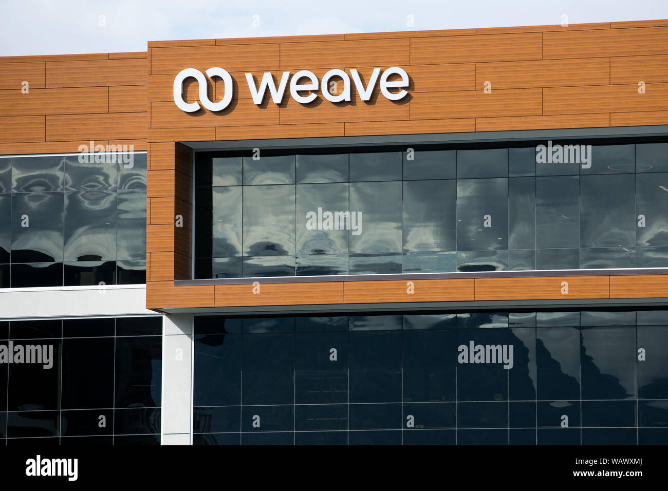 A logo sign outside of a facility occupied by software provider Weave ...
