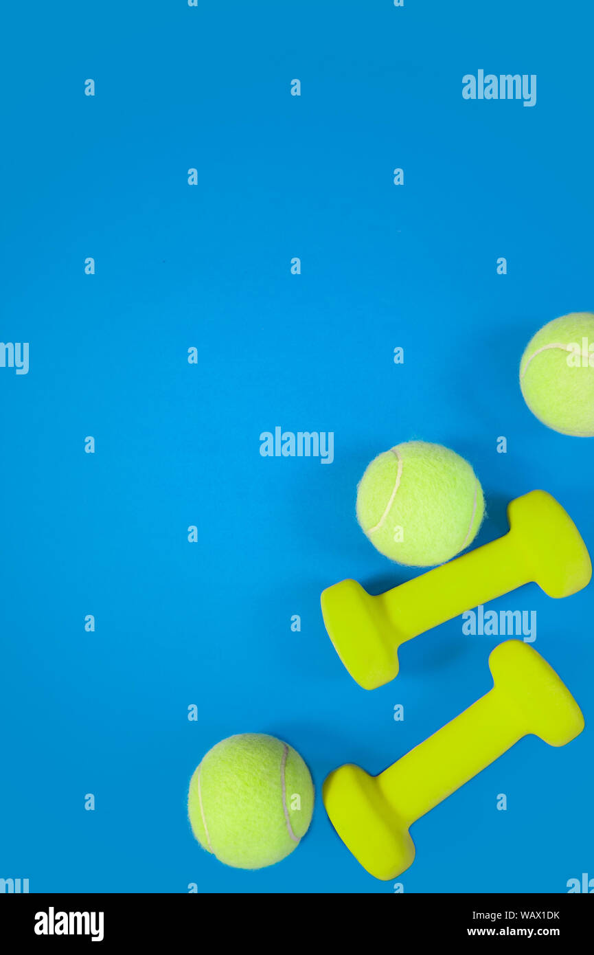 workout concept fitness background dumbells tennis ball on blue background Stock Photo