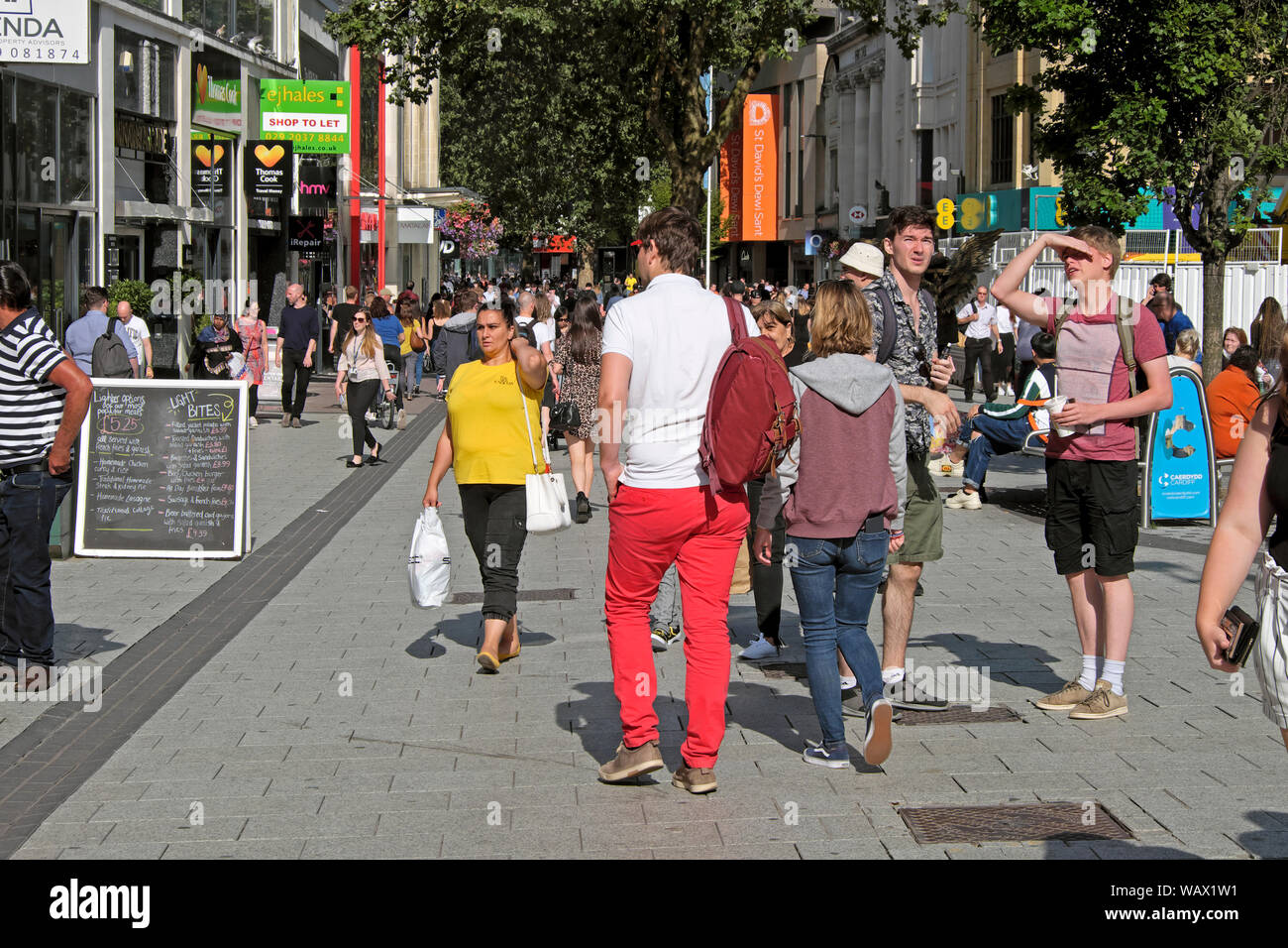 Cardiff Queen Street shopping area people shoppers walking past shops on a sunny day in summer July 2019 in Cardiff City Centre Wales UK  KATHY DEWITT Stock Photo