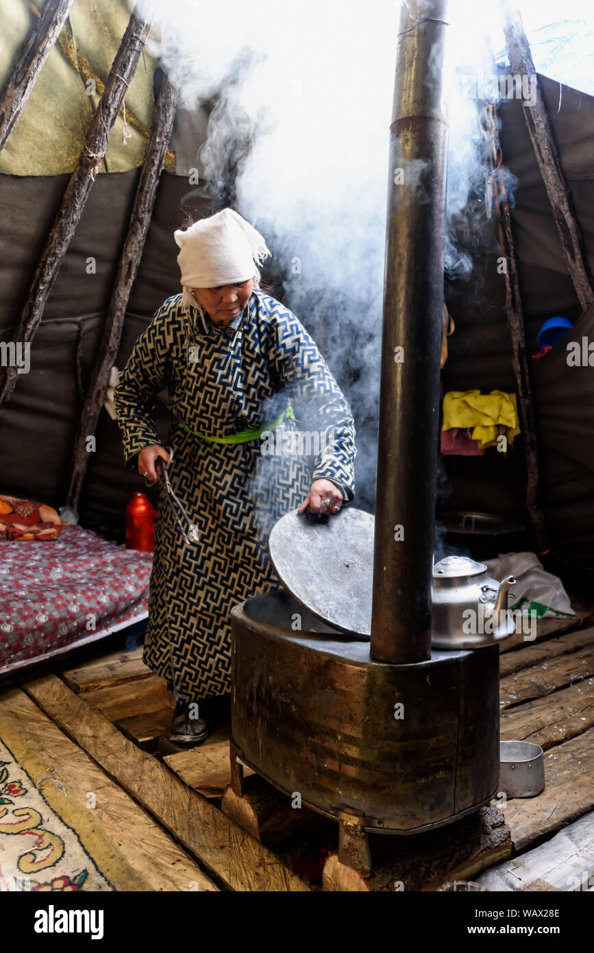 Hatgal, Mongolia, Febrary 24, 2018: Mongolian woman cooking foog inside yurt. Stock Photo