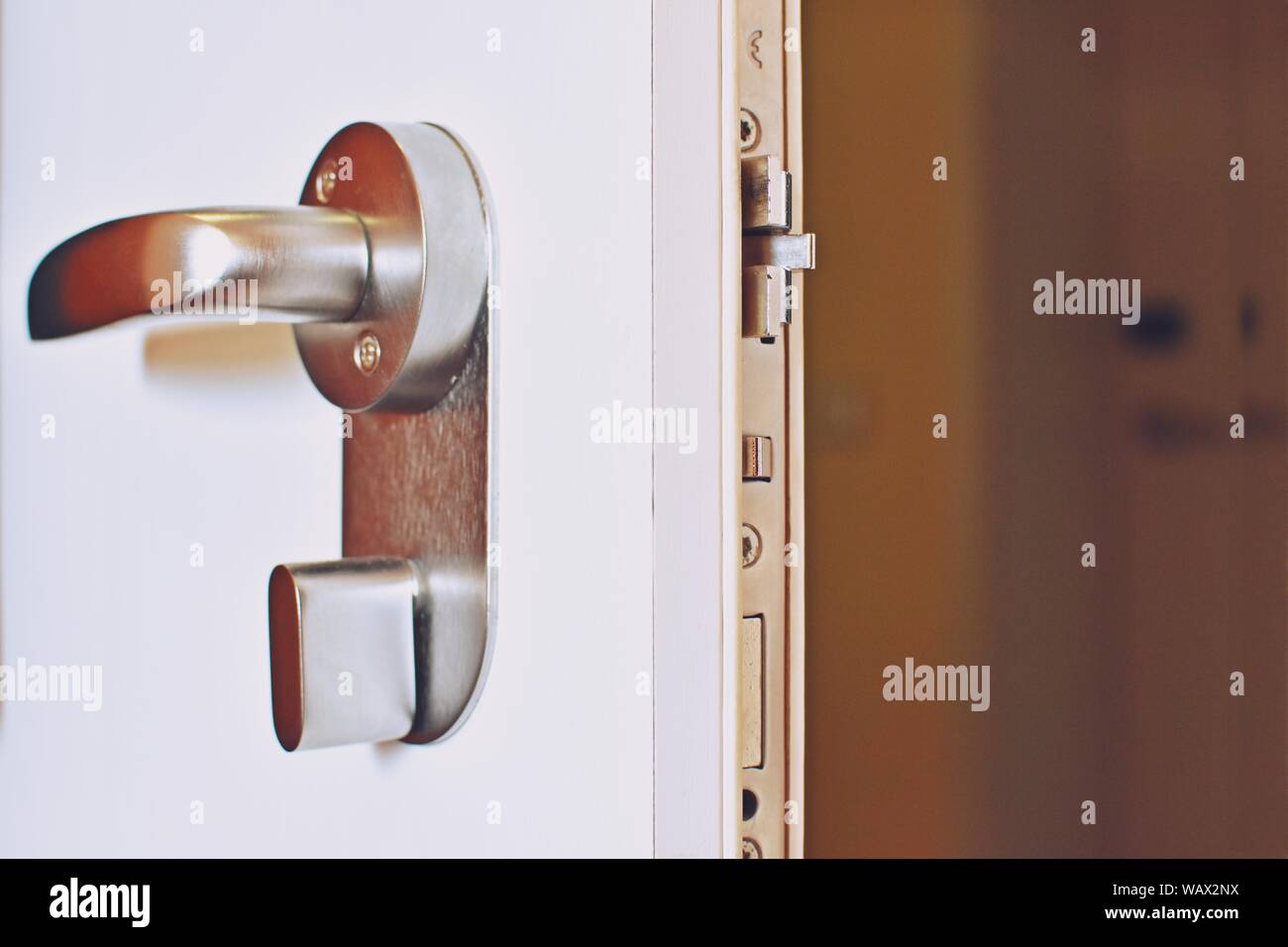 Close up of an open door with a metallic secure lock doorknob. Stock Photo