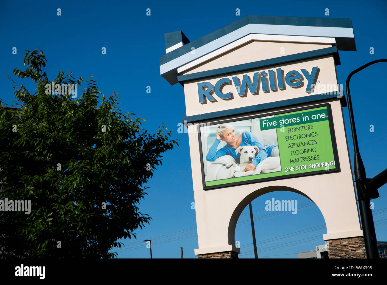 A logo sign outside of a RC Willey Home Furnishings retail store