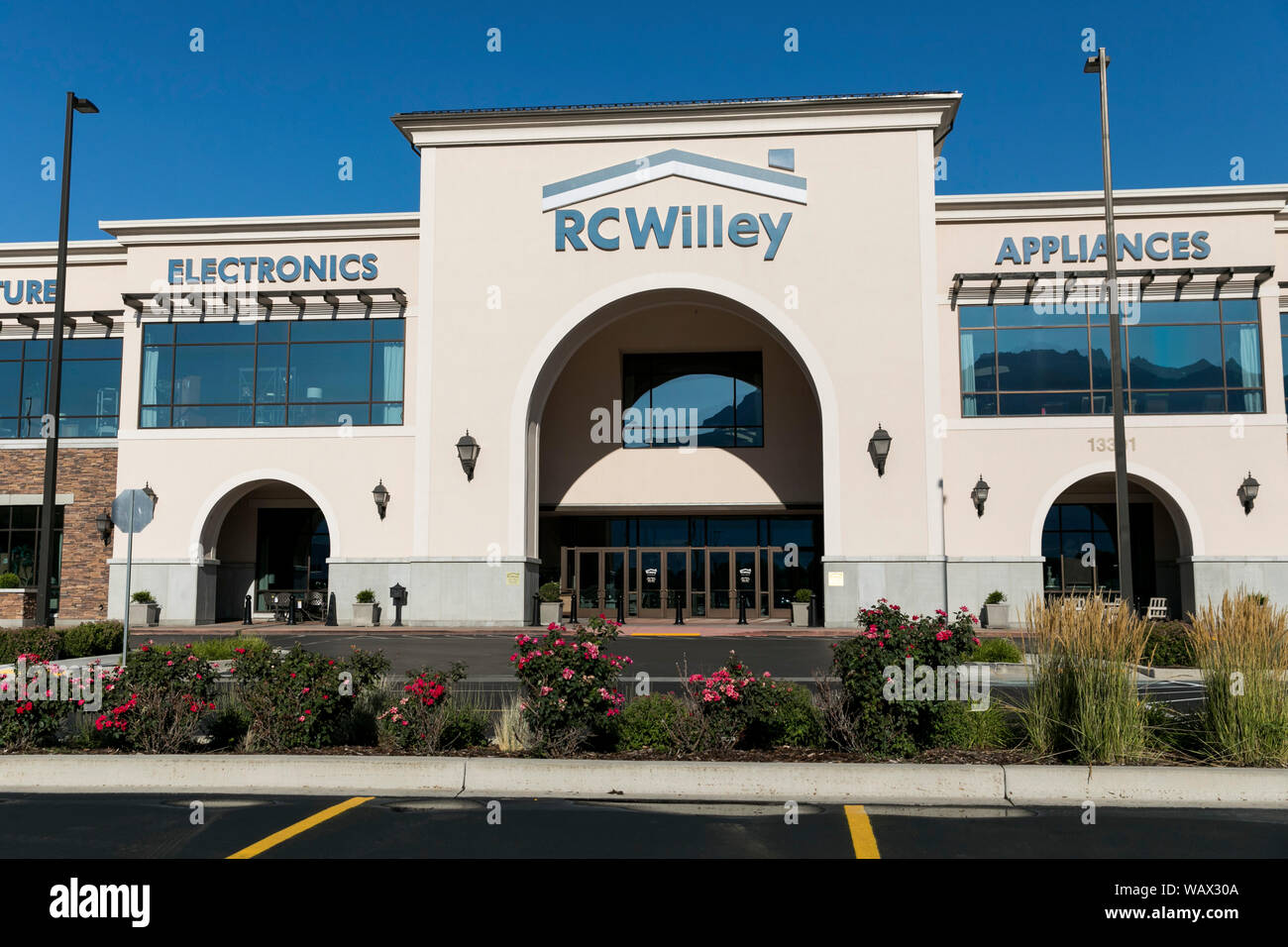 A logo sign outside of a RC Willey Home Furnishings retail store