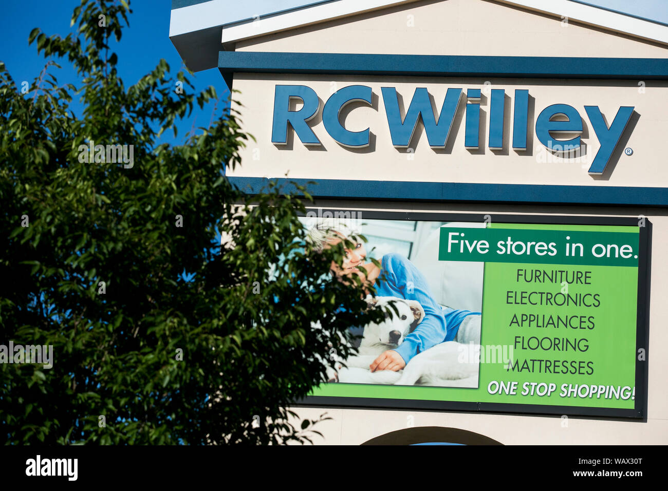 A logo sign outside of a RC Willey Home Furnishings retail store
