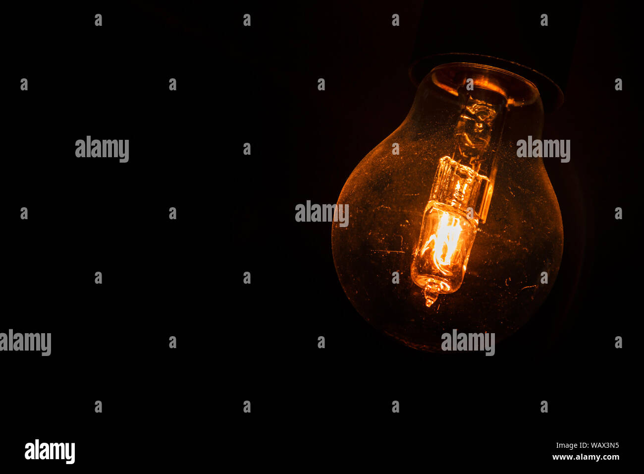 Lightbulb glowing in the dark. Stock Photo