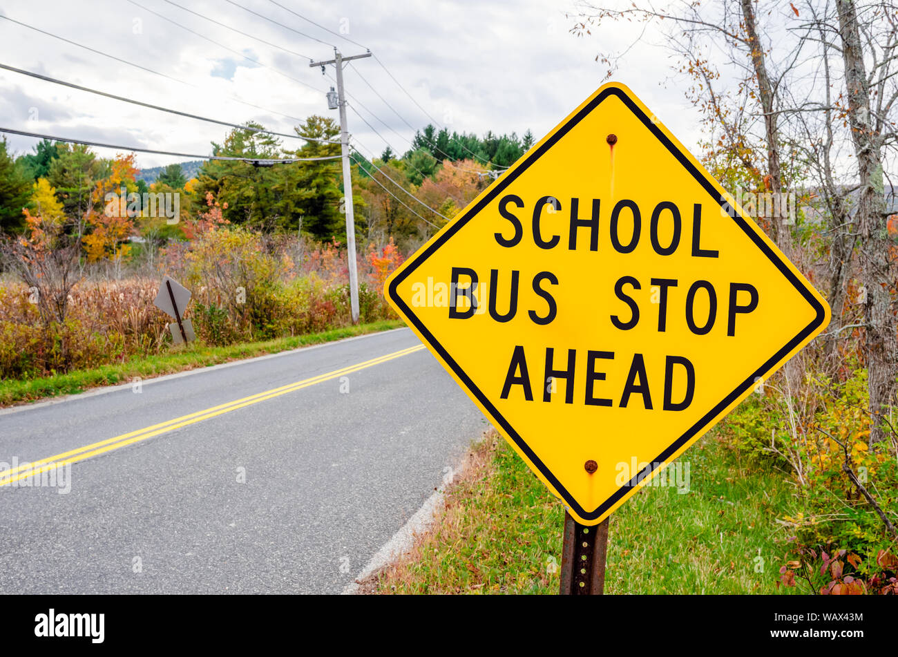 School bus stop ahead Warning road sign on a cloudy autumn day. Back to school concept. Stock Photo