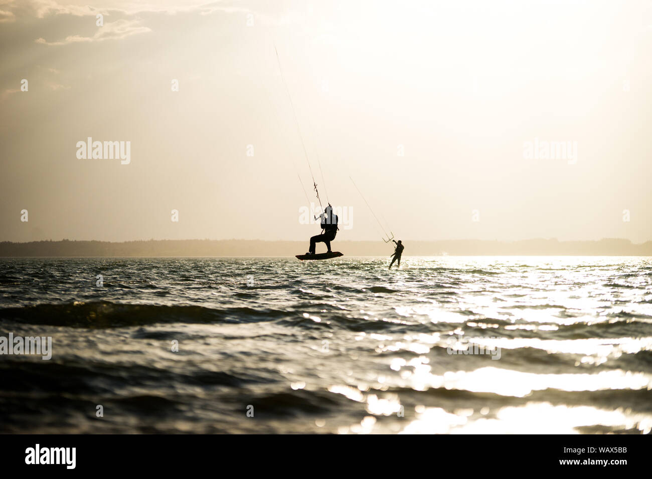 Silhouettes of kitesurfers on the Chiemsee Stock Photo