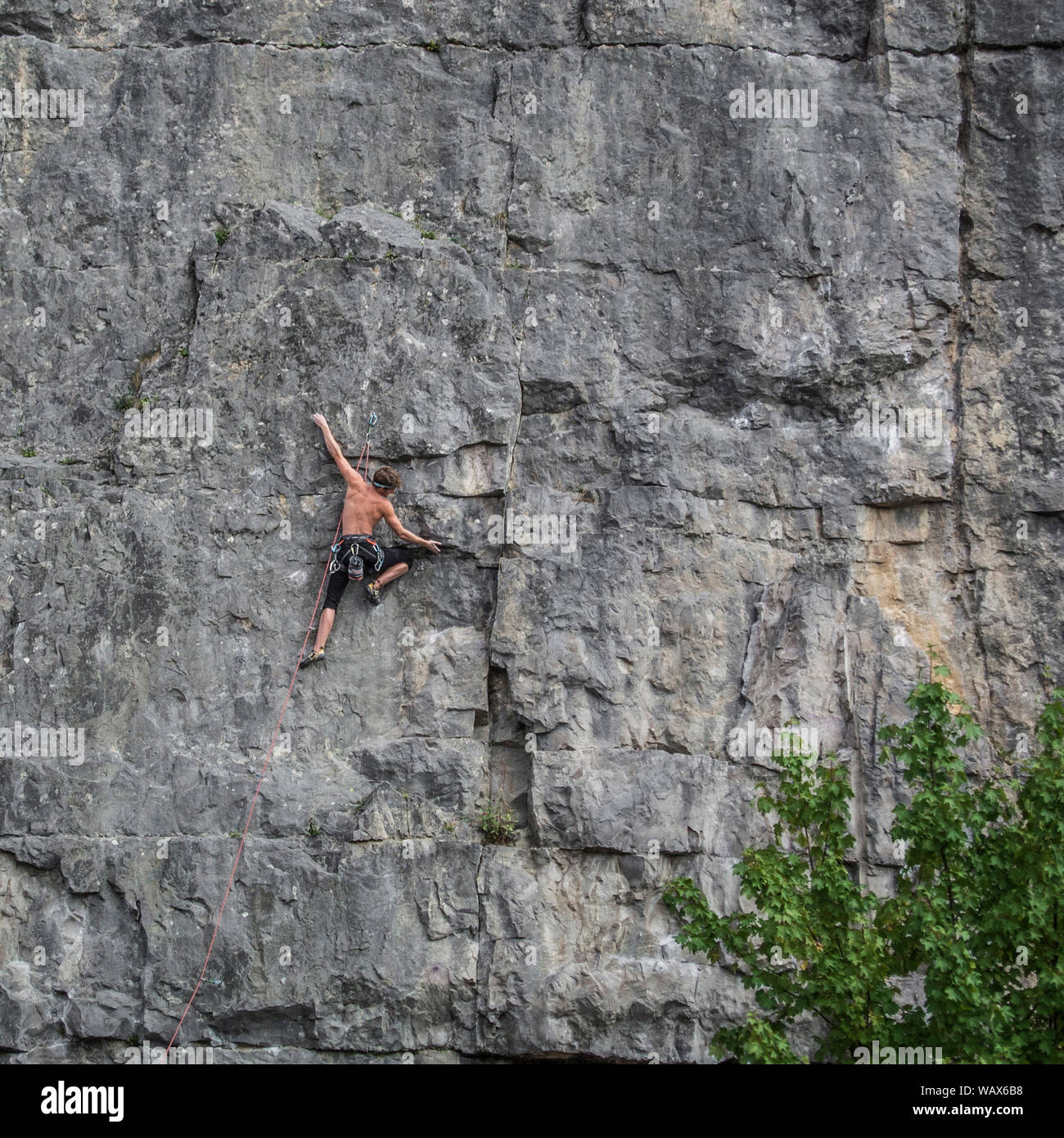 Climber on large rock face. Horseshoe Quarry, Peak district, Derbyshire