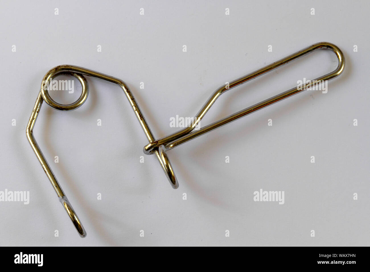 Overhead view of a wire third hand tool used to pull bicycle brakes together in order to adjust them, isolated on a plain background Stock Photo