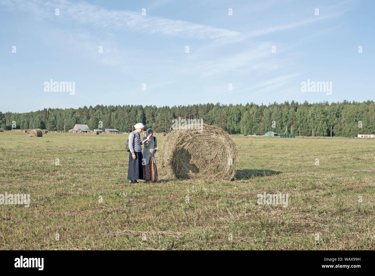 Two Pilgrims pray in the field on the Apalayevsk site. Stock Photo