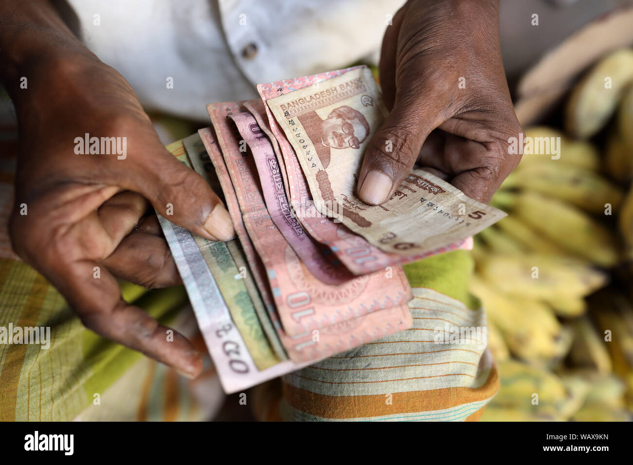 Market vendor counts money in Dhaka, Bangladesh Stock Photo