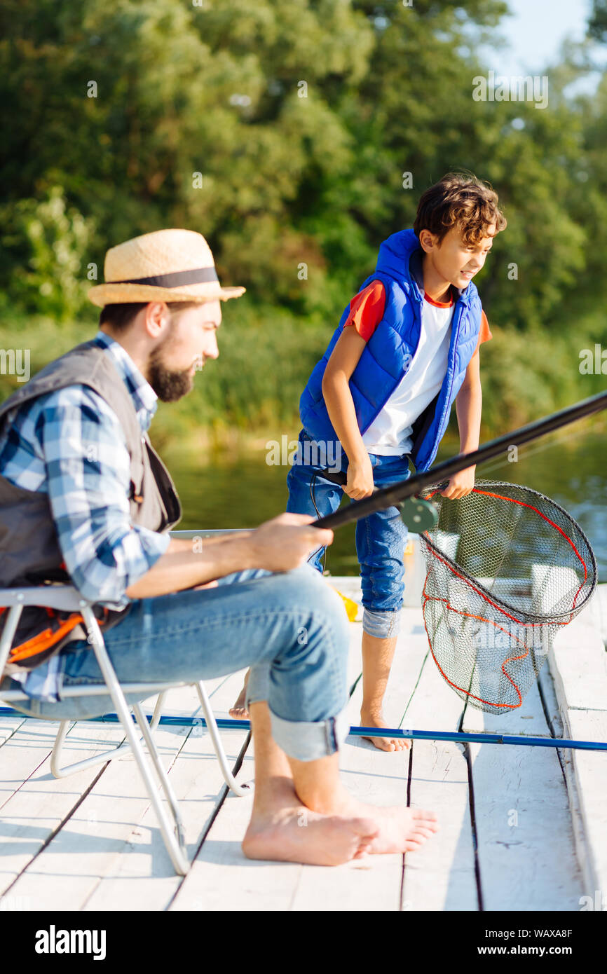 Boy Wearing Yellow Rain Coat Smiling while Fishing Stock Photo