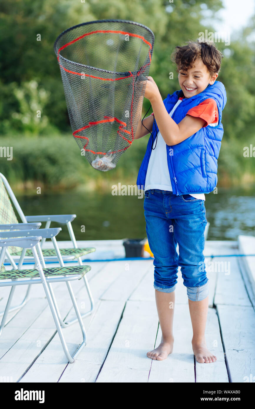 Boy holding fishing net fish hi-res stock photography and images - Alamy