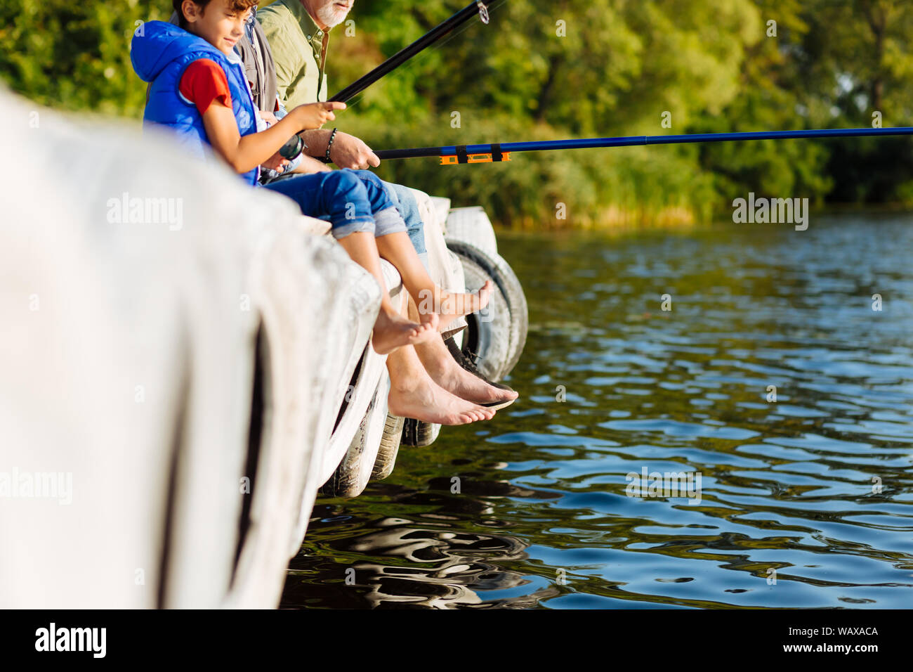 boy fishing with grandfather at lake Stock Photo - Alamy