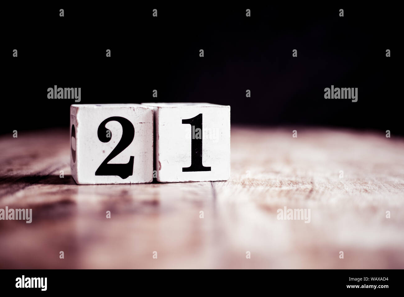 Number 21 isolated on dark background- 3D number twenty one isolated on vintage wooden table Stock Photo