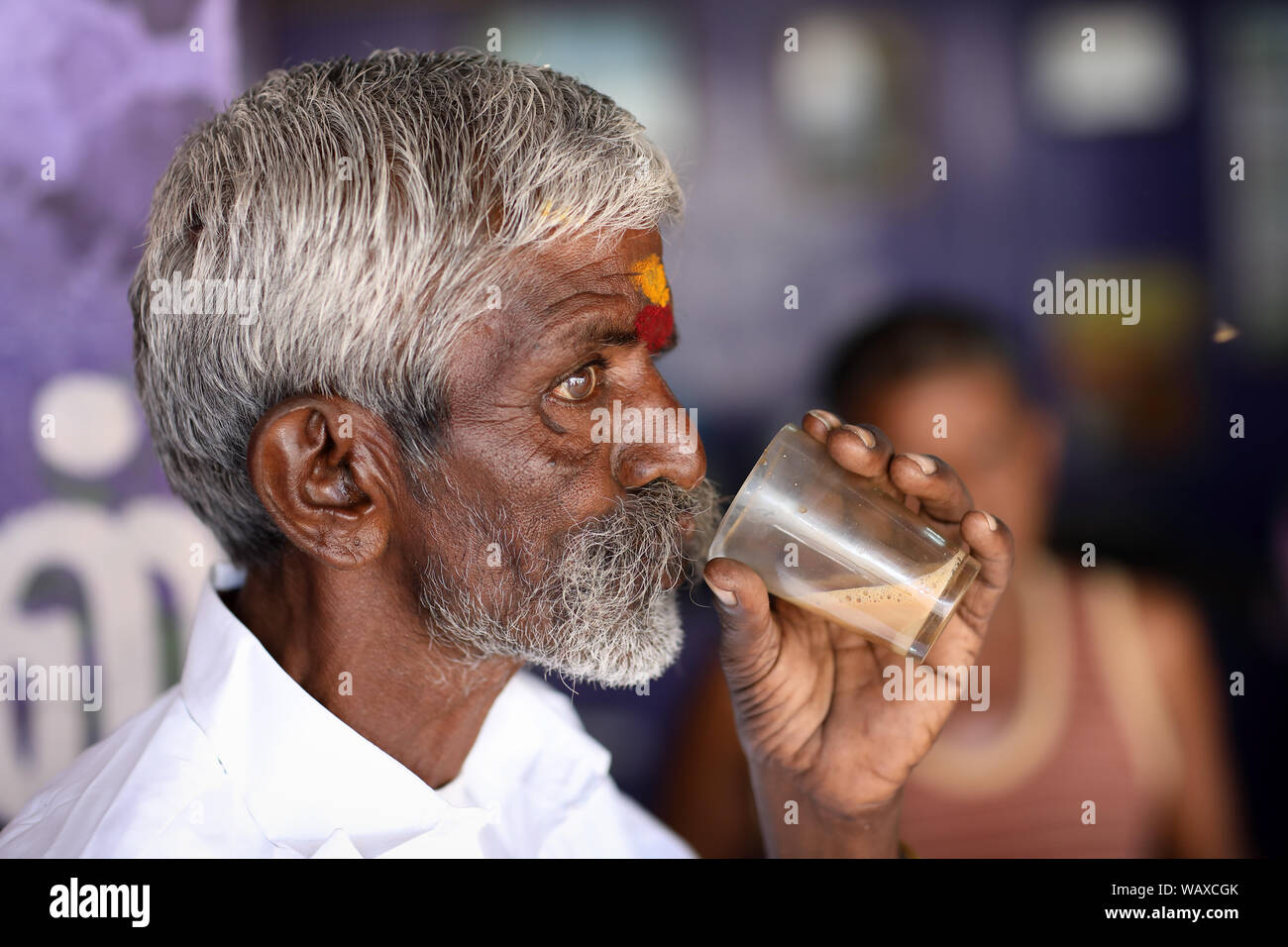 Tea wallah drinks tea in a small traditional stall in Madurai, India. Stock Photo