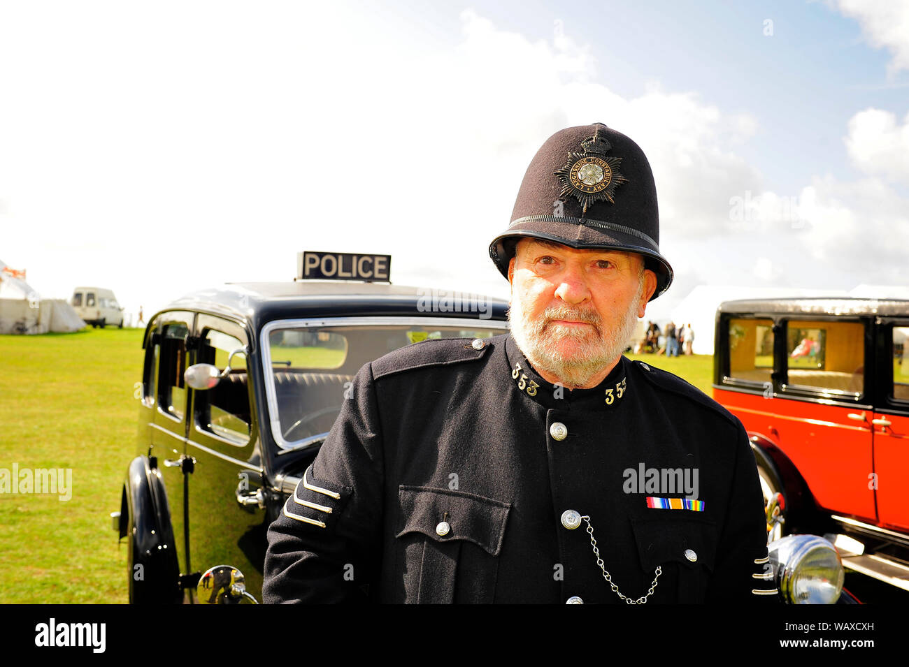 1940s wartime weekend,Lytham,Lancashire,UK. Lancashire Constabulary police officer stood next to a 1938 Wolseley series 3 police car Stock Photo