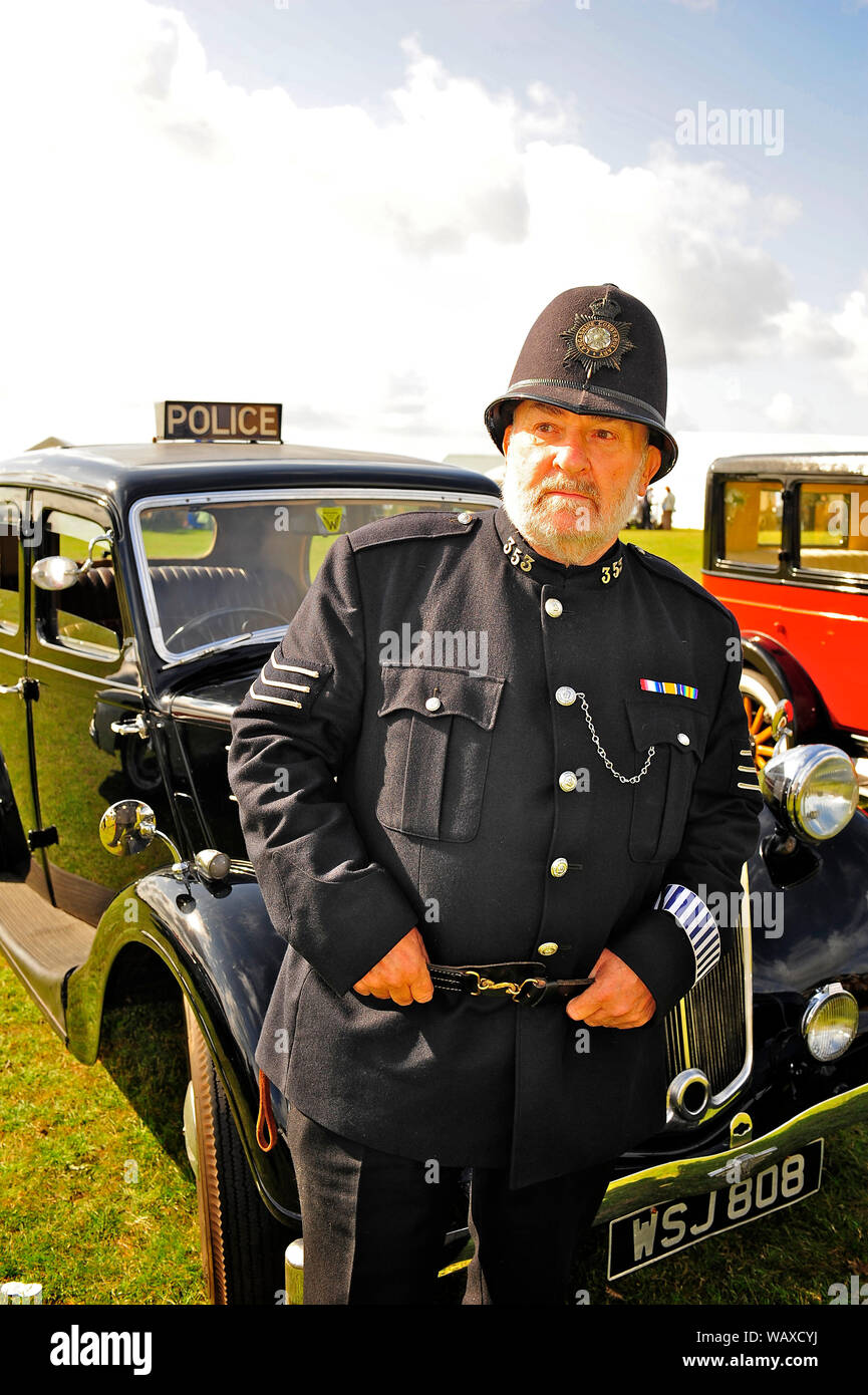 1940s wartime weekend,Lytham,Lancashire,UK. Lancashire Constabulary police officer stood next to a 1938 Wolseley series 3 police car Stock Photo