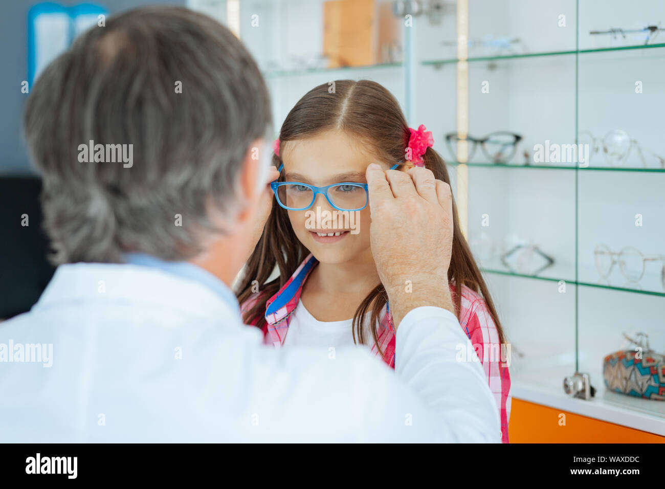 Pleasant cute girl trying on new glasses Stock Photo