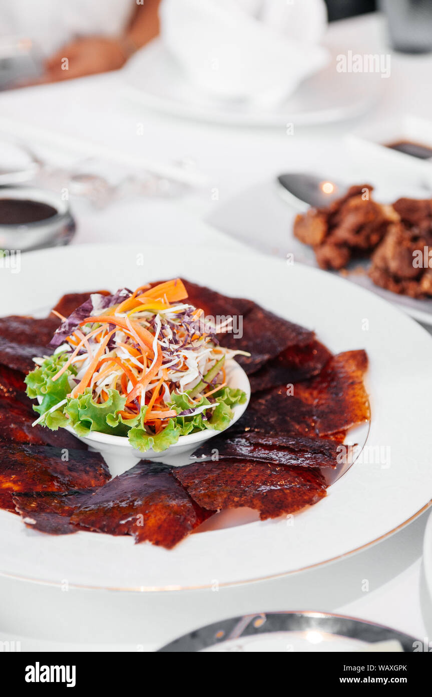 Roasted Peking duck or Beijing duck crispy skin with sweet Hoisin sauce and  salad on white plate. close up shot Stock Photo - Alamy
