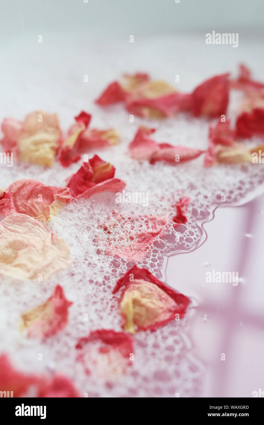Bath with foam and flower petals Stock Photo