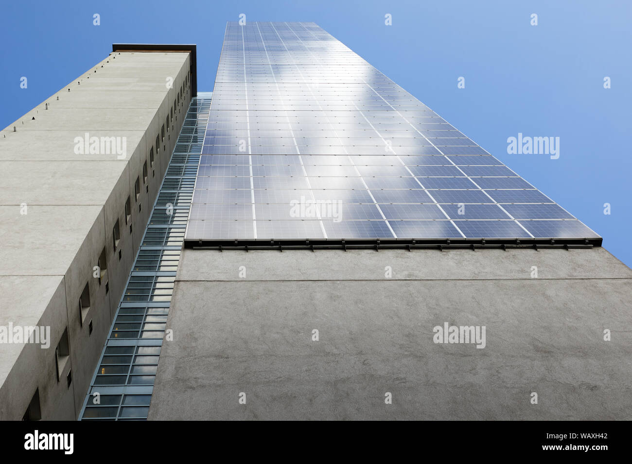 London, U.K. - August 17, 2019: Solar photovoltaic cells fitted to the side of high-rise local-authority residential tower block. Stock Photo