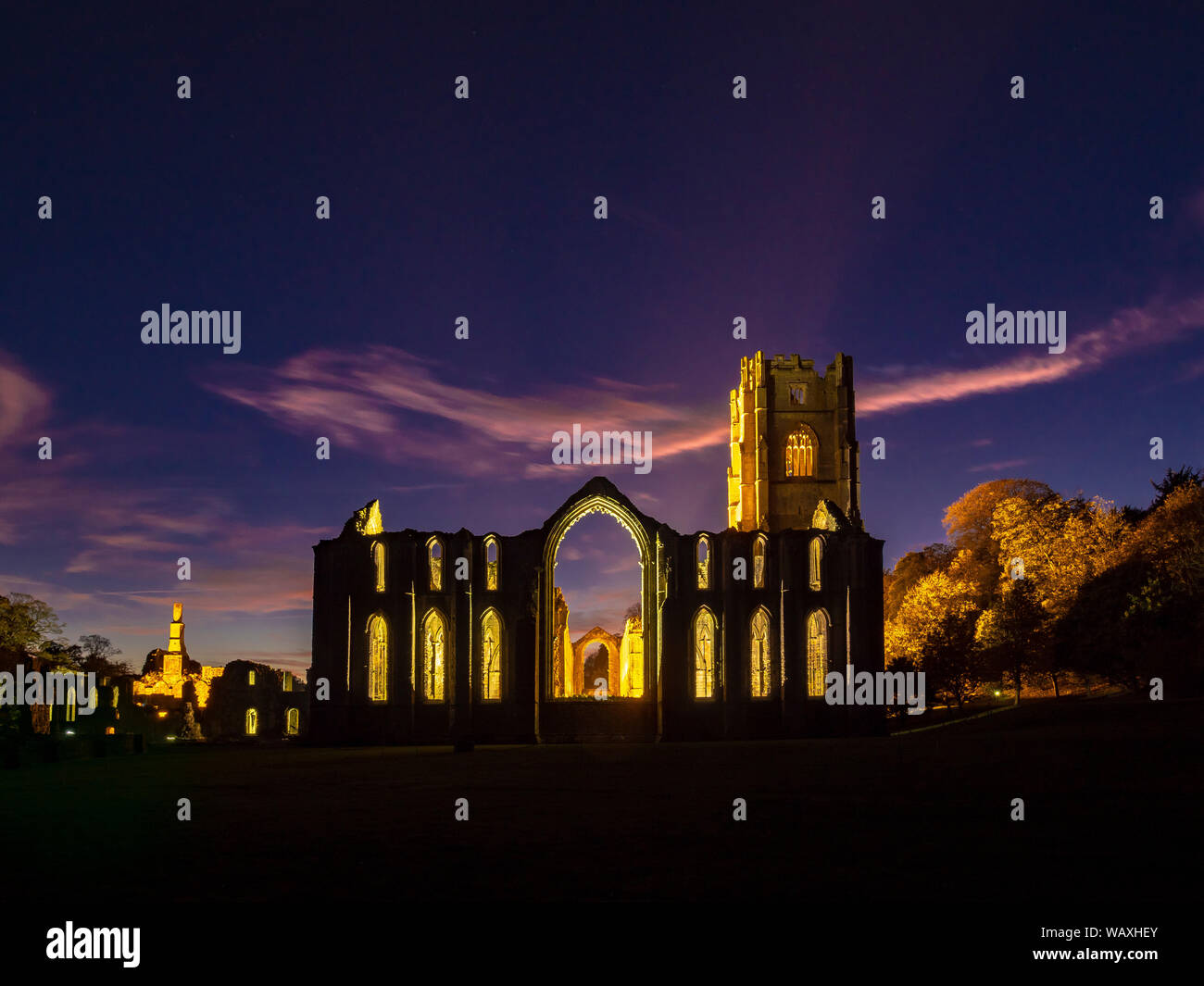 Ruins of Fountains Abbey illuminated at night, within the grounds of