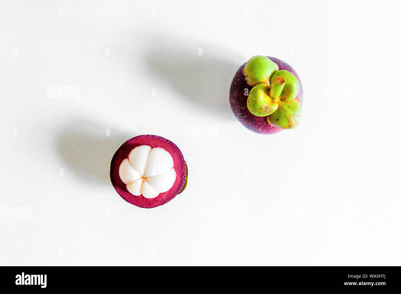 Isolated whole cut open mangosteen on white background. Top angle Stock