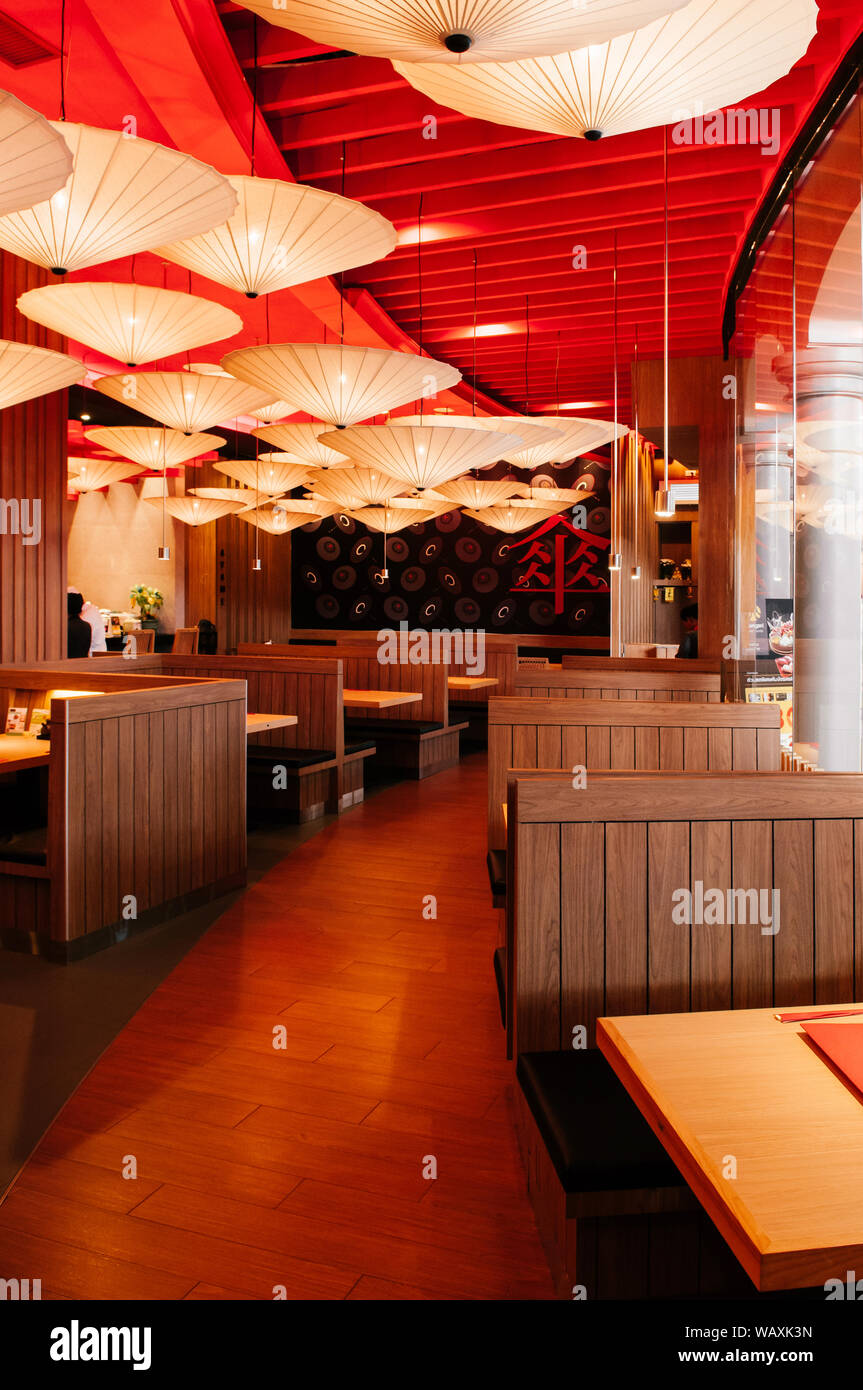 OCT 30, 2013 Bangkok, THAILAND - Vibrant Japanese restaurant interior, decorated ceiling with paper umbrellas, warm tone lighting and wooden furniture Stock Photo