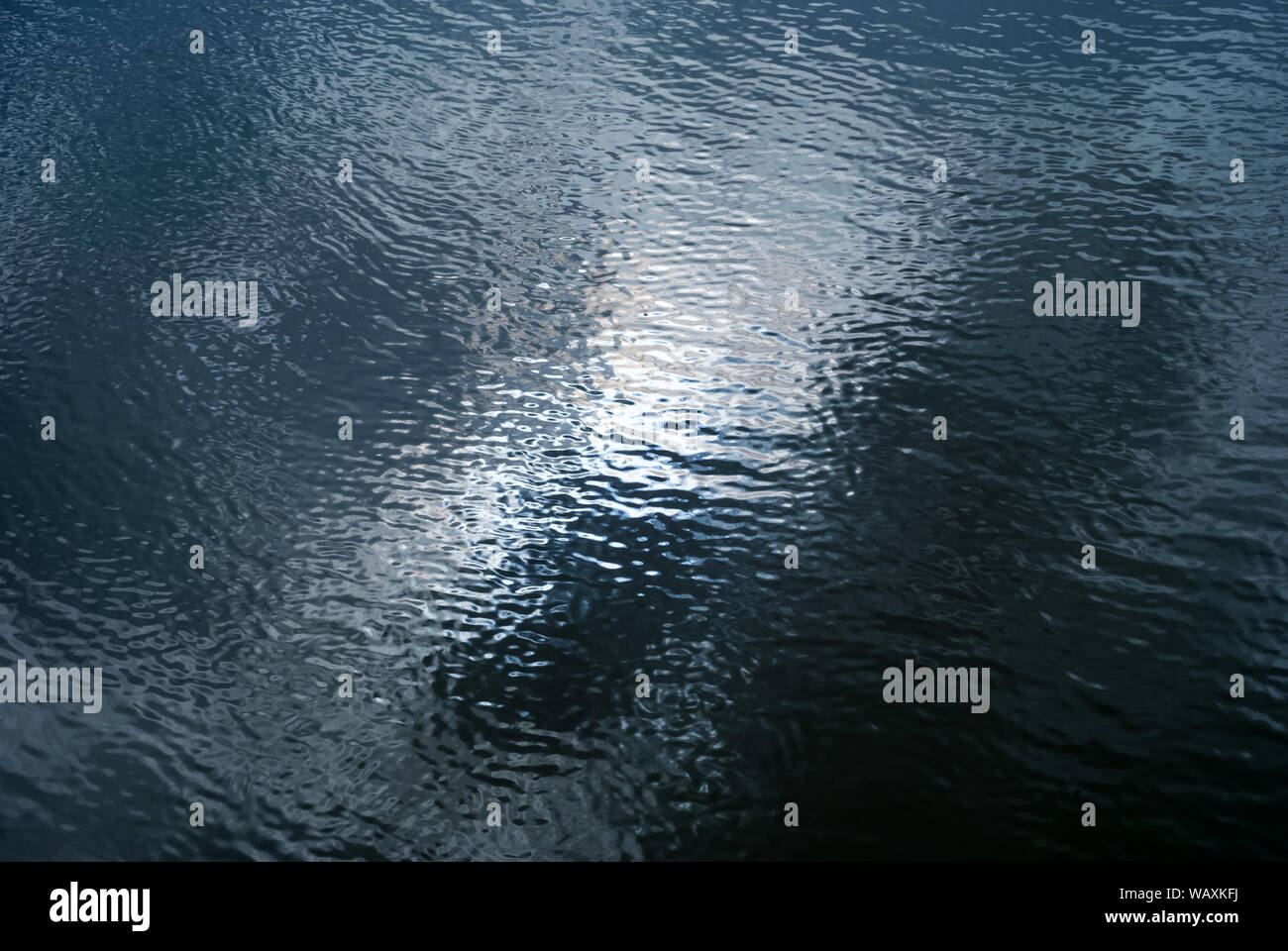 background - shiny glossy water surface with ripples and sky reflection ...
