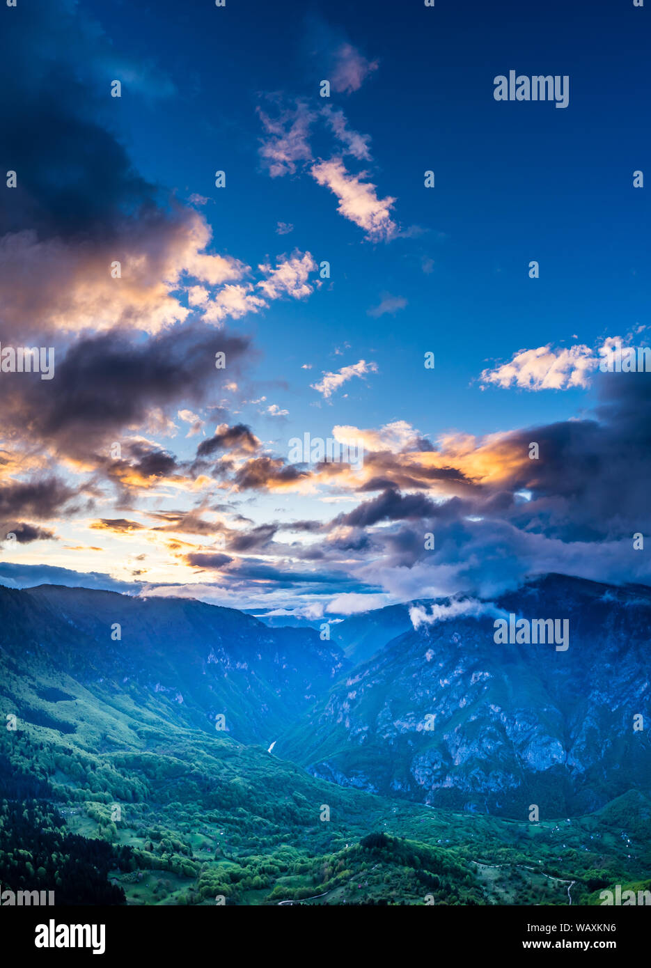 Montenegro, Blue sky and glowing clouds of colorful sunset sky over world famous ravine of tara river canyon from above at dawn in beautiful durmitor Stock Photo