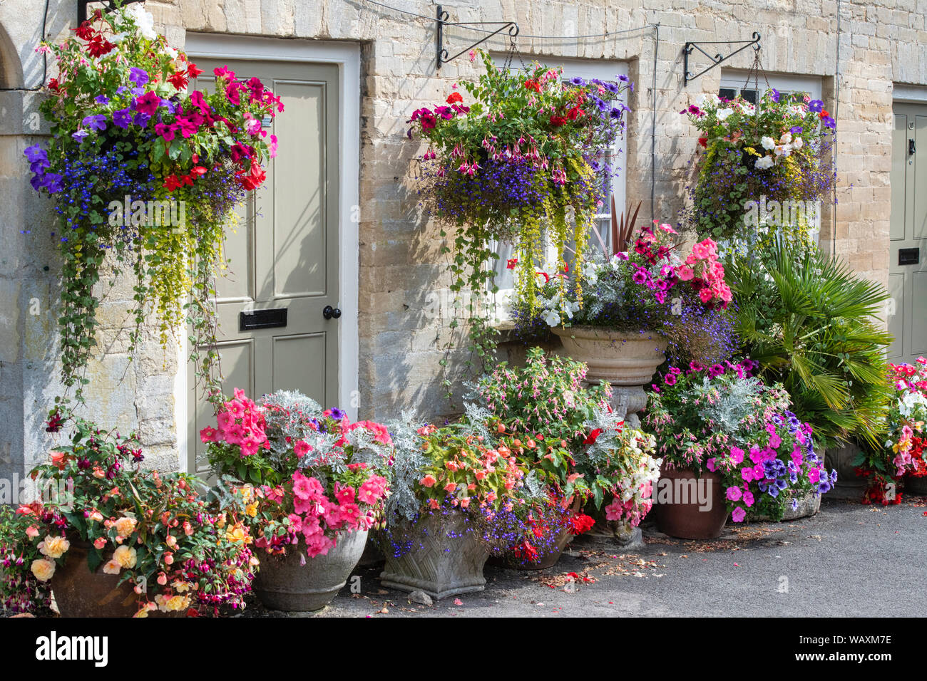 Floral hanging baskets and flower planters outside the Tontine Buildings along Cecily hill, Cirencester, Cotswolds, Gloucestershire, England Stock Photo