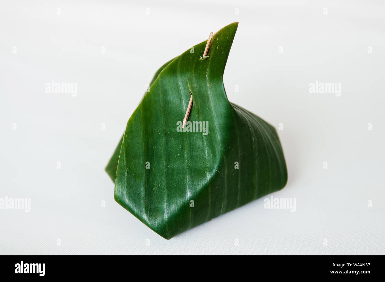 Traditional Thai banana leaf wrapped dessert isolated on white