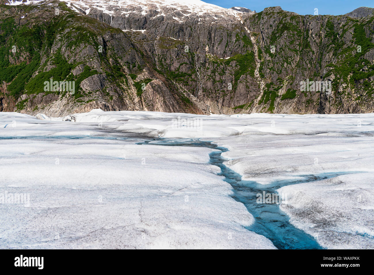 closeup of the surface of the mendenhall glacier near juneau alaska with the canyon wall in the background Stock Photo