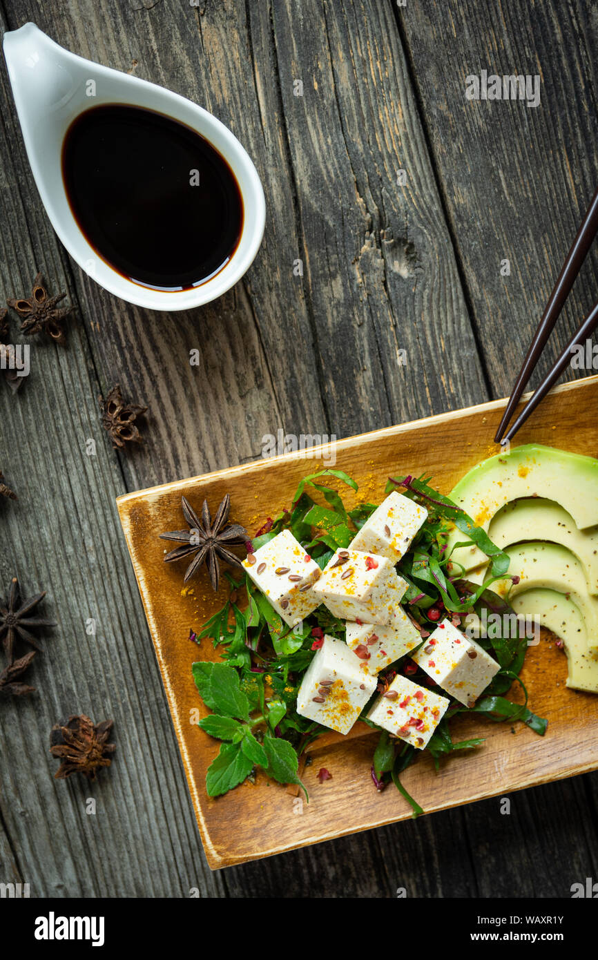 tofu on plate and wooden table with vegetables and colorful fruit with soy sauce Stock Photo