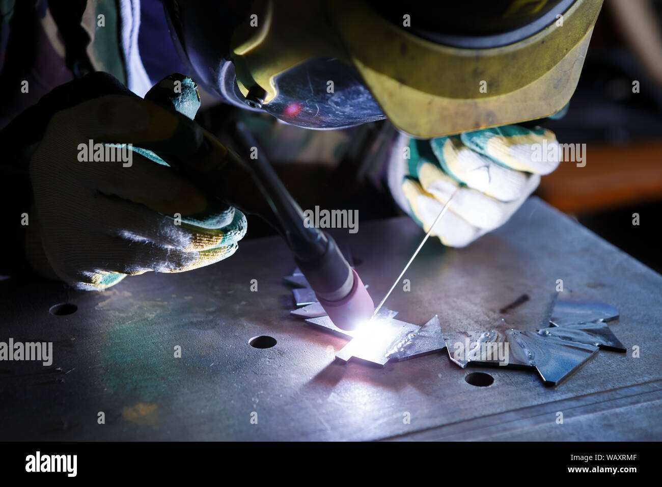 Professional woman welder working with electric torch wearing