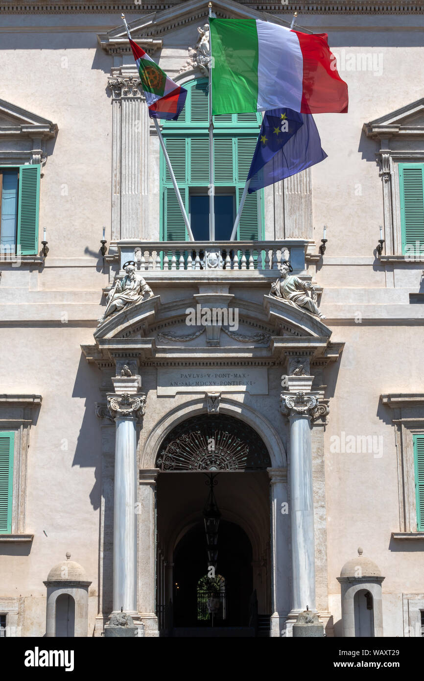 Rome, Italy - August 22, 2019: Quirinale, main entrance of the building, with fluttering flags. Institutional seat of the President of the Italian Rep Stock Photo
