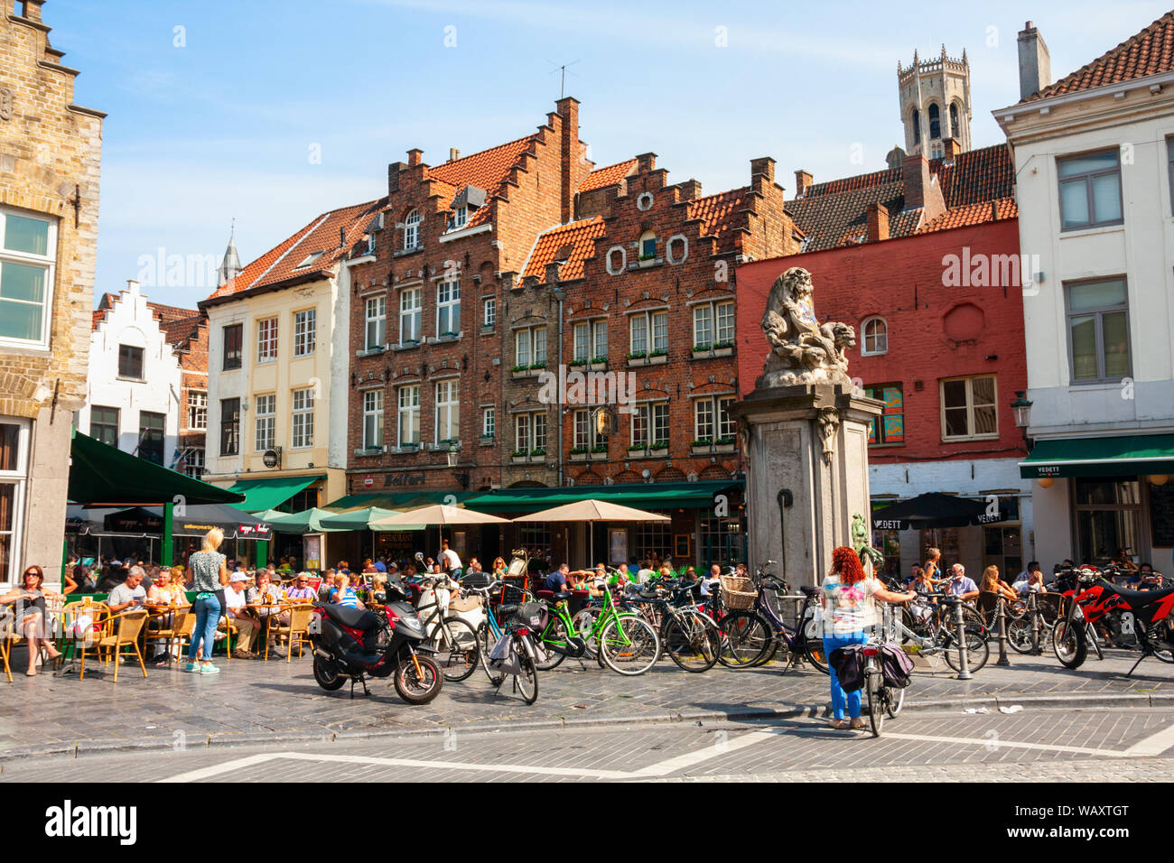 BRUGES, FLANDERS, BELGIUM - AUGUST 1, 2019: Unidentified tourists sitting at a terrace at the Eiermarkt (Egg market) and the Geernaartstraat, part of Stock Photo