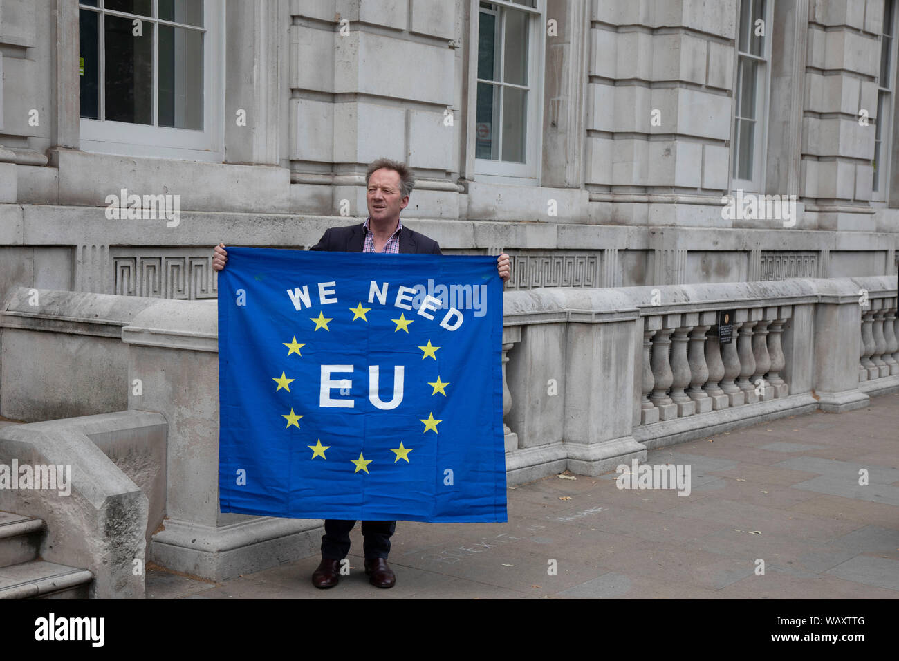 Anti Brexit protester with a European Union flag reading We need EU outside the Cabinet Office in Westminster as inside the Tory Cabinet meets to discuss Brexit on 16th August 2019 in London, England, United Kingdom. Stock Photo