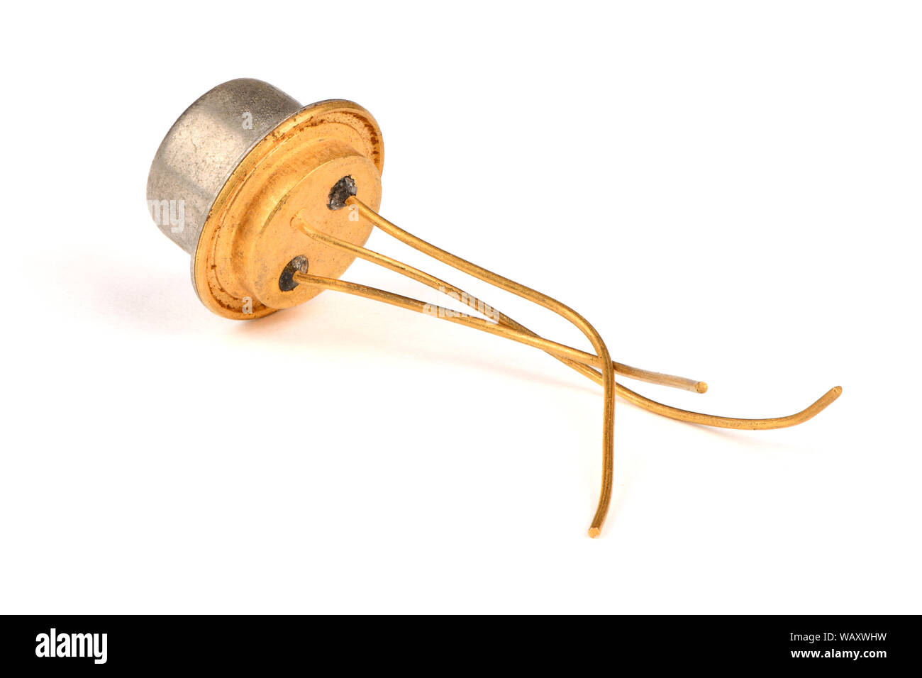 Old radio component, the semiconductor transistor with the contacts covered with gold on a white background. High resolution photo. Full depth of fiel Stock Photo