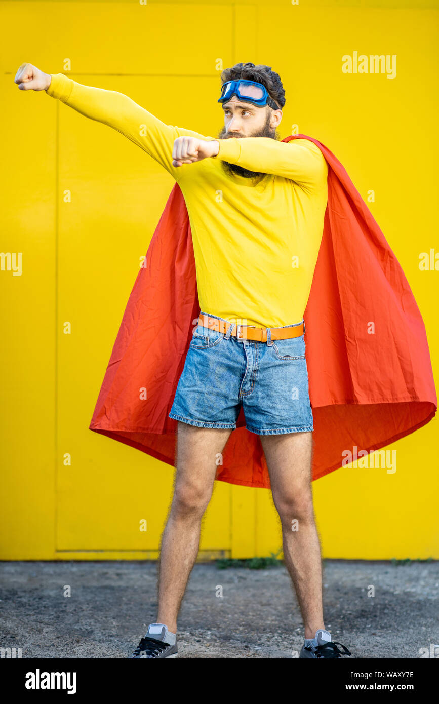 Portrait of a man like a superhero in colorful clothes and pilot's