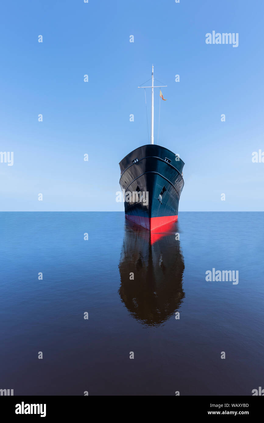 Front view of the bow of an ocean going liner / ship on a tranquil and calm empty sea with a distant horizon and clear blue sky with nobody in sight, Stock Photo