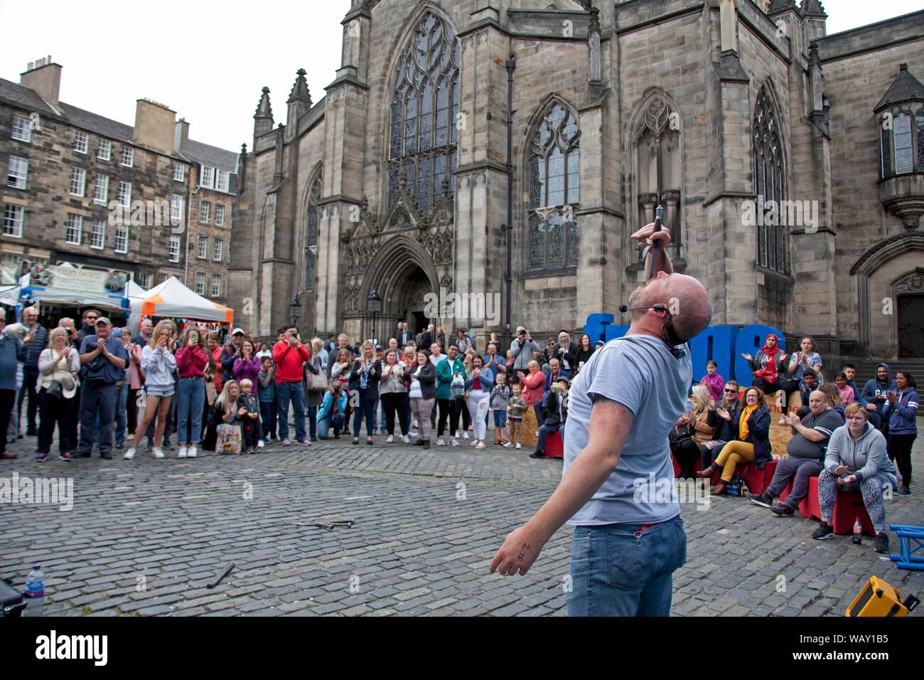 Royal Mile, Edinburgh, Scotland, UK. 22nd August 2019. Edinburgh Fringe Festival action is slowing down a little on this last Thursday on the High Street, there was more space to walk around and less flyering taking place. The musicians are still entertaining audiences and the stages were still in action and of course the Street Performers are still sword swallowing. Side show Stevie from Perth sword swallowing. Stock Photo